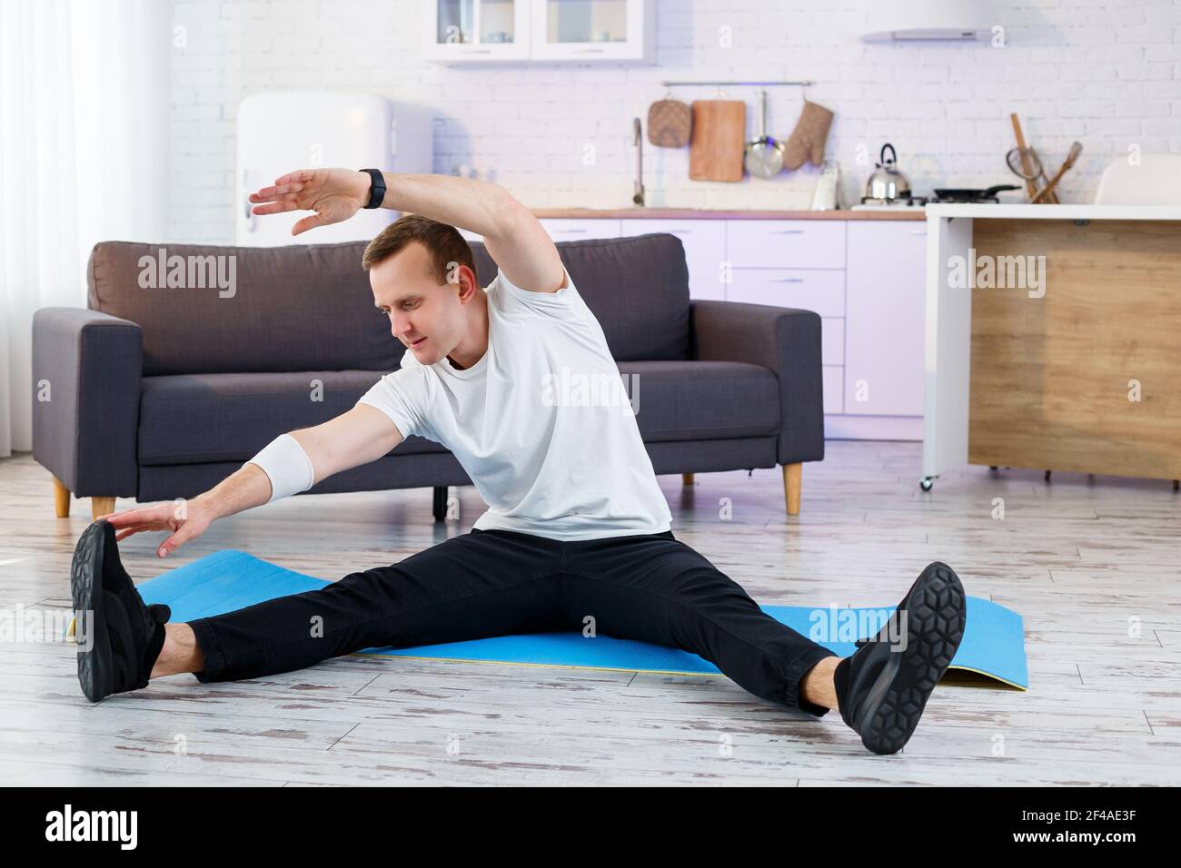 Muscular Athletic Man In A T Shirt Doing Warm Up Exercises At Home Doing Sports At Home During The Quarantine Period Fitness Outside The Gym Stock Photo Alamy