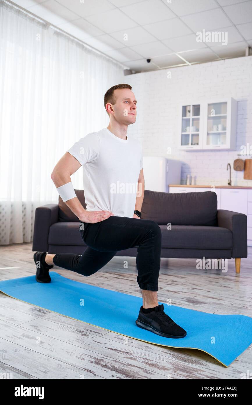 Muscular Athletic Man In A T Shirt Doing Warm Up Exercises At Home Doing Sports At Home During The Quarantine Period Fitness Outside The Gym Stock Photo Alamy