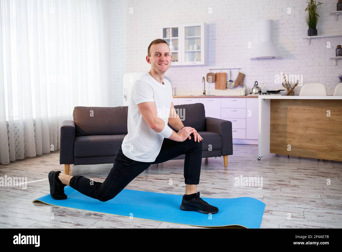 Muscular Athletic Man In A T Shirt Doing Warm Up Exercises At Home Doing Sports At Home During The Quarantine Period Fitness Outside The Gym Stock Photo Alamy