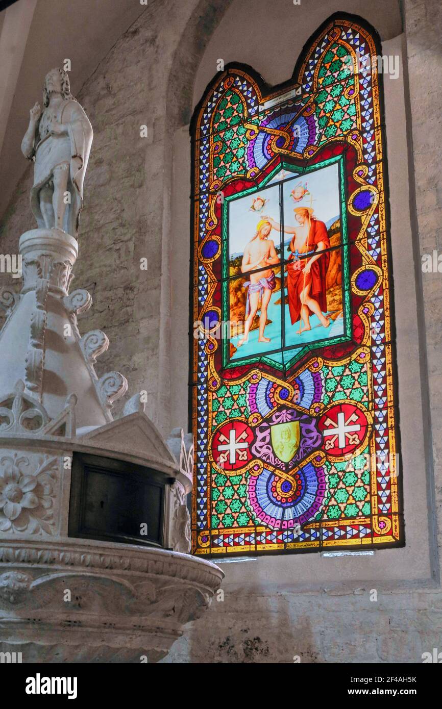 Todi, Umbria, Italy.  Stained glass in the Santa Maria Annunziata Duomo depicting John the Baptist baptizing Jesus.  It was begun in the 12th century Stock Photo