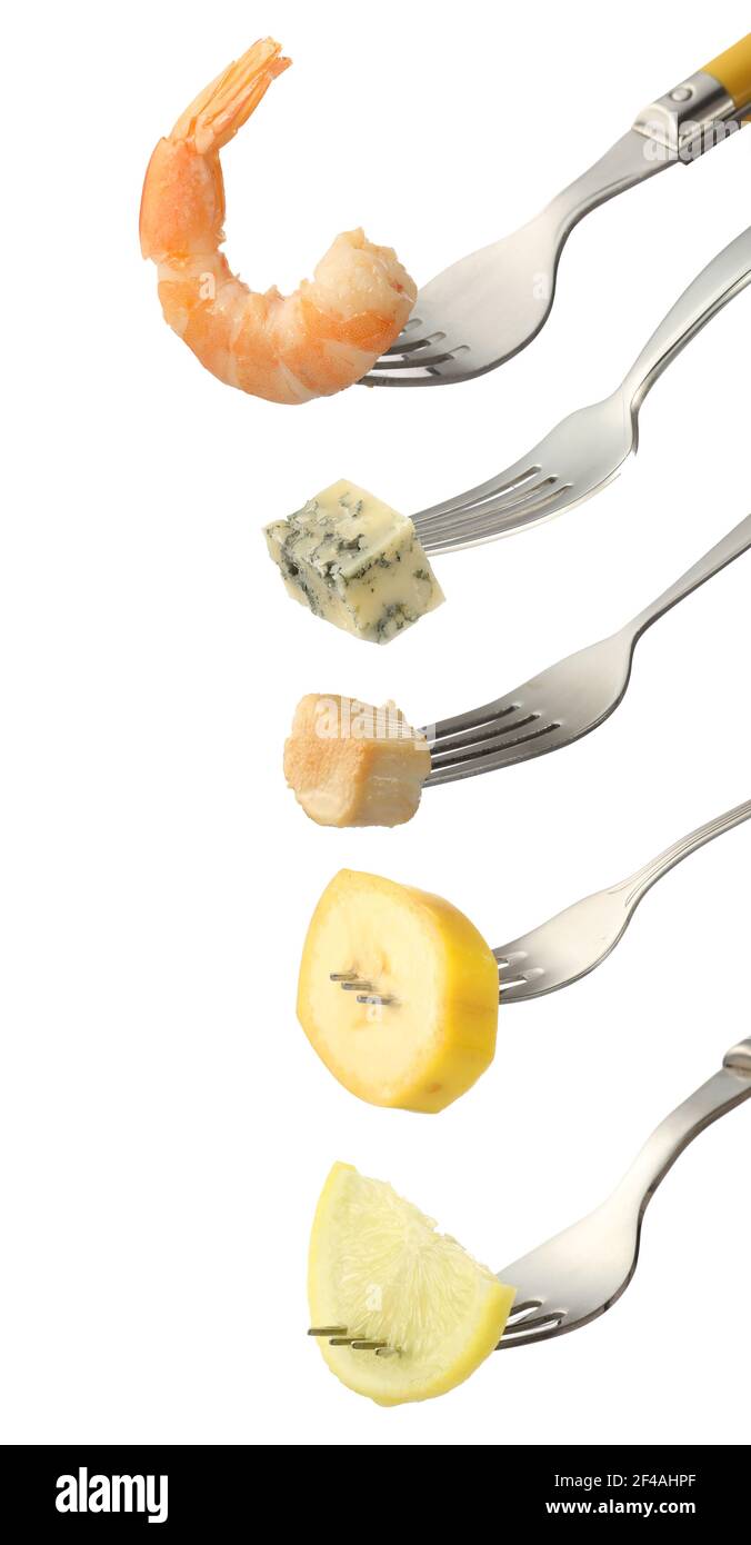 Different food impaled on forks against white background Stock Photo