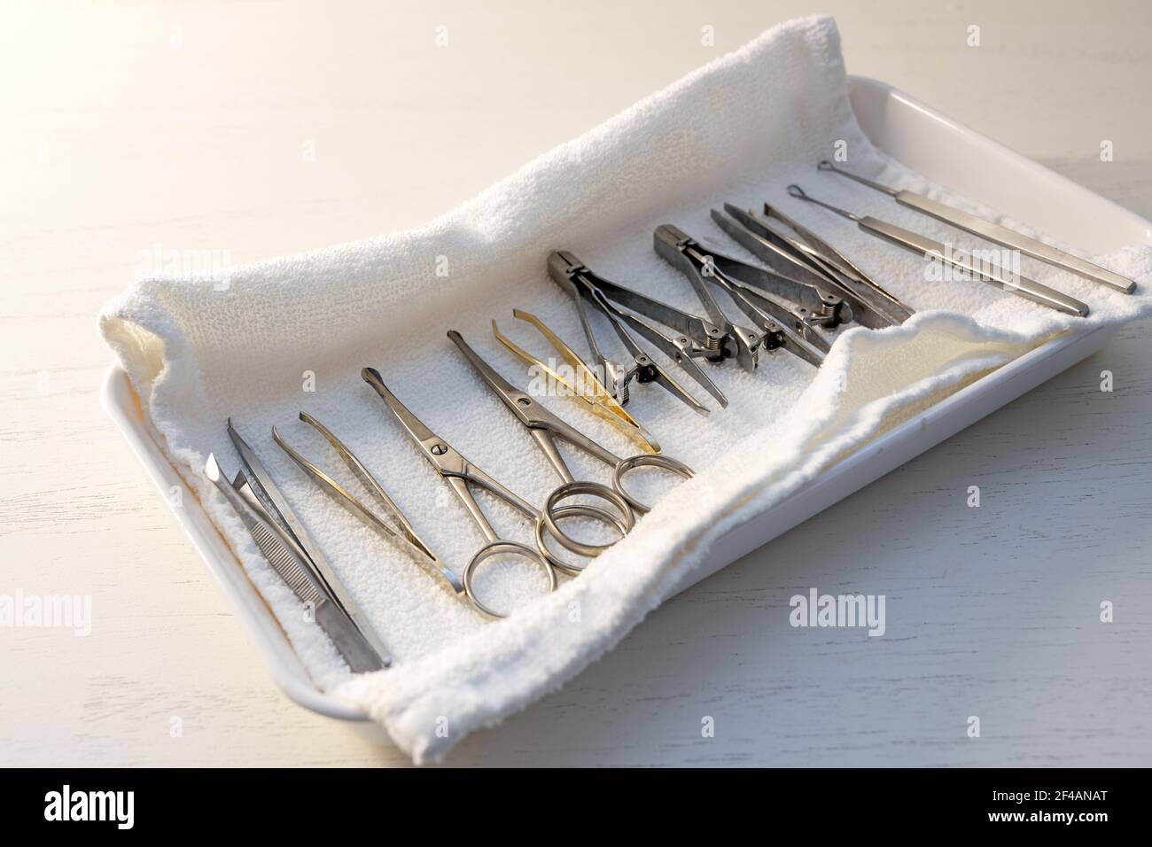 tools for manicure and pedicure like scissors, pincers and pinchers in a bowl with a white terry cloth, light background, copy space, selected focus, Stock Photo