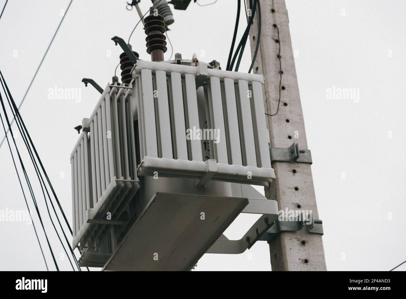 A low angle shot of an electrical transformer on a pole Stock Photo