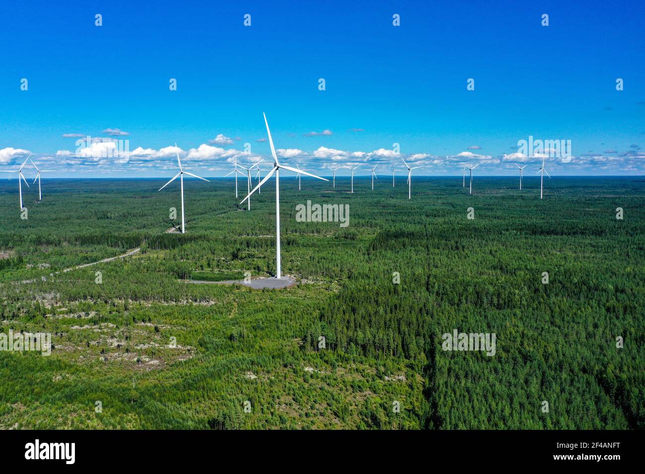 Aerial view of many windmills at a wind power farm, on a sunny, summer day, in Satakunta, Finland - Dolly, drone shot Stock Photo