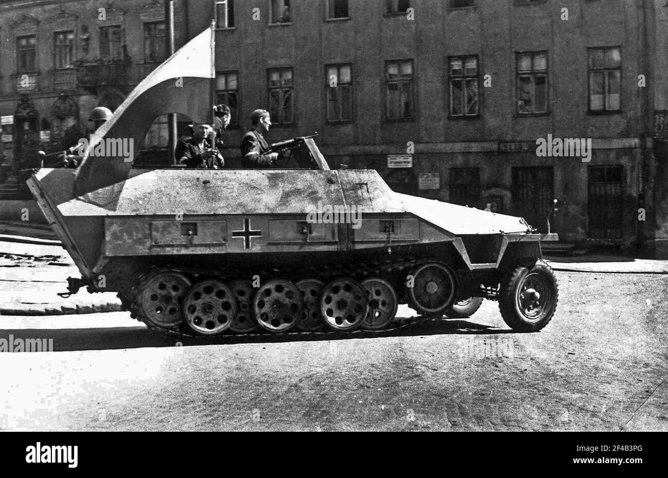 WarsawUprising: German armored fighting vehicle SdKfz 251 captured by the Polish insurgents, from 8-th 'Krybar' Regiment, on Na Skarpie Boulevard on August 14, 1944 from 5th SS 'Viking' division. In this picture taken on Tamka Street, soldier with MP-40 submachine gun is his first insurgent commander Adam Dewicz 'Gray Wolf' Stock Photo