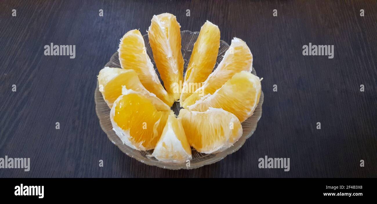 orange slices in a glass cup on a wooden table Stock Photo