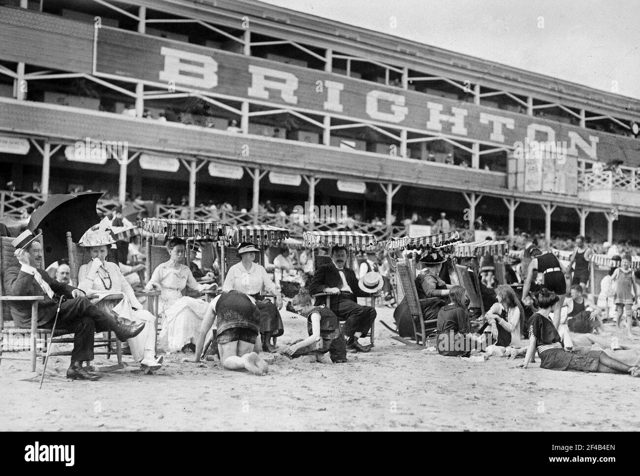 Men and women on Brighton Beach, Brighton Baths in the background ca. 1910-1915 Stock Photo