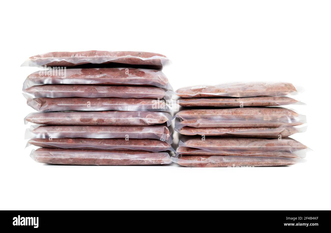 Frozen ground meat packages in stacks with backs, necks, liver and heart. Left chicken, right turkey. Concept for raw food diet for pets. Or chicken v Stock Photo