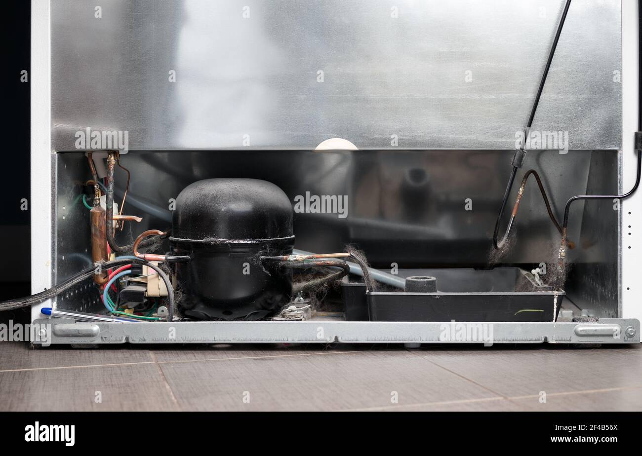 Back of the Refrigerator. View of fridge backside with compressor condenser, corroded copper