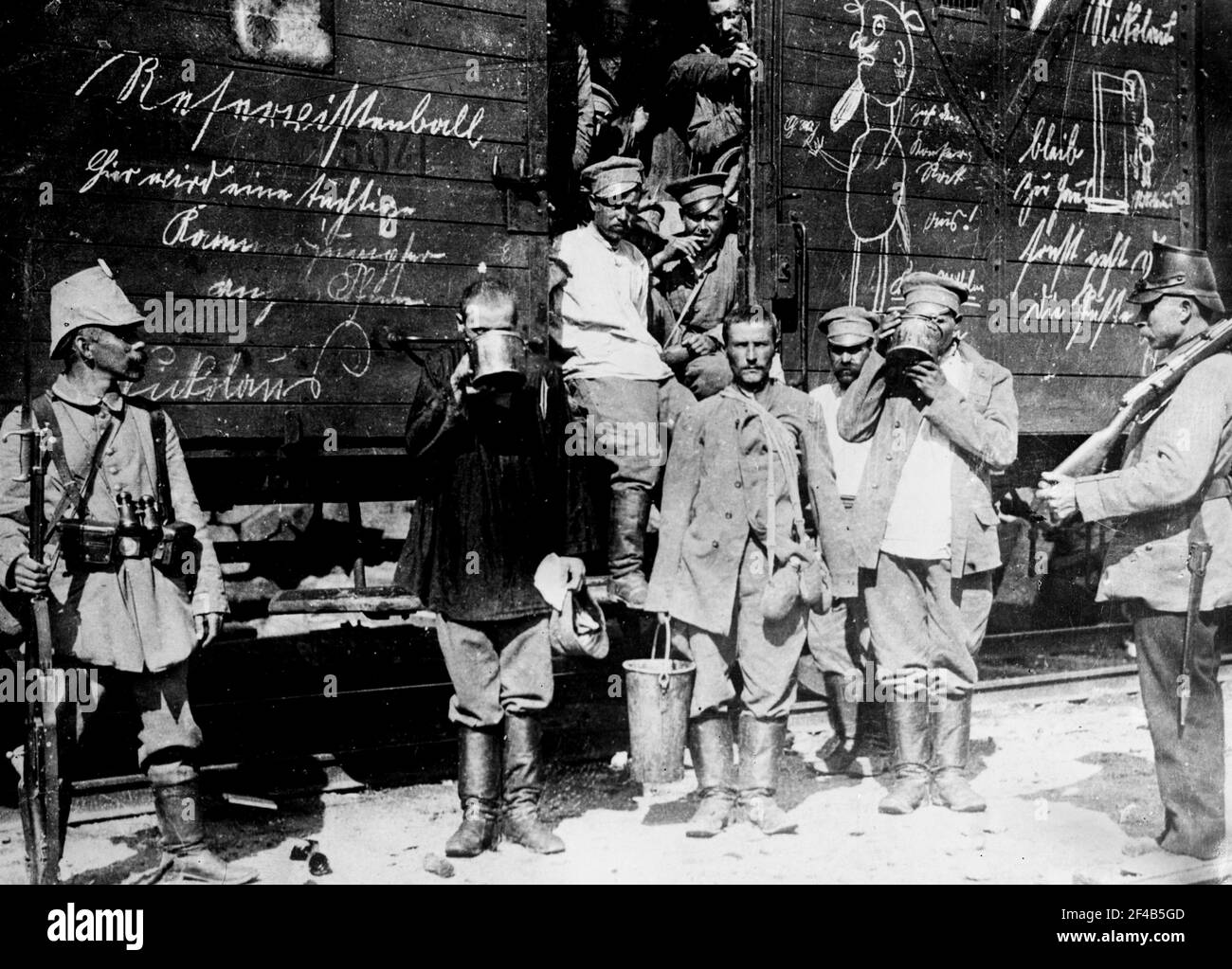 Russian prisoners in East Prussia, standing by a railroad car, drinking from large cups during World War I  ca. 1914 Stock Photo