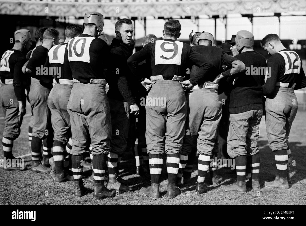 Huddle of players for the Brown University football team, including: Left Guard William Wallace Wade (1892-1986) (player no. 10) and Left Tackle Walter Kenneth Sprague, (player no. 9) during the game against Cornell which was held on October 24, 1914 at the Polo Grounds (Brush Stadium) in New York city Stock Photo