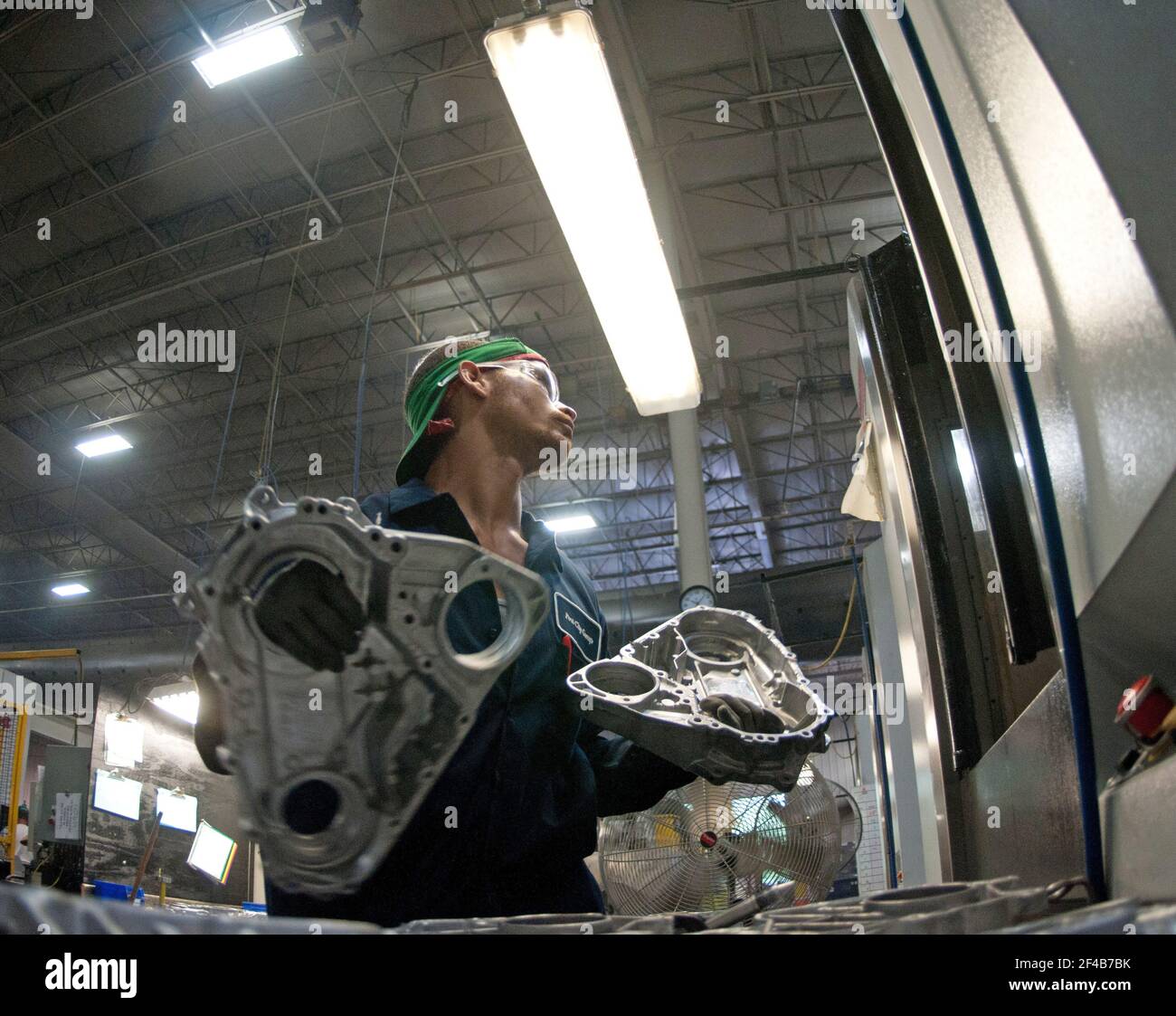 Computer Numerical Control (CNC) machine operator Blake Veeneman makes a process inspection after a casting is machined at Port City Group’s Port City Castings Corporation manufactures high-pressure aluminum die-castings, mostly for the automotive industry, in Muskegon, MI, facility on Wednesday July 20, 2011.  Port City Group boosted its employment by 12 percent over last year thanks to two Rural Business Guaranteed Loans totaling $9.6 million. In its 80,000 sq. ft. facility, machines that range from 800 – 1,600 tons, and cast A380 aluminum alloy products from melted ingots of aluminum, into Stock Photo