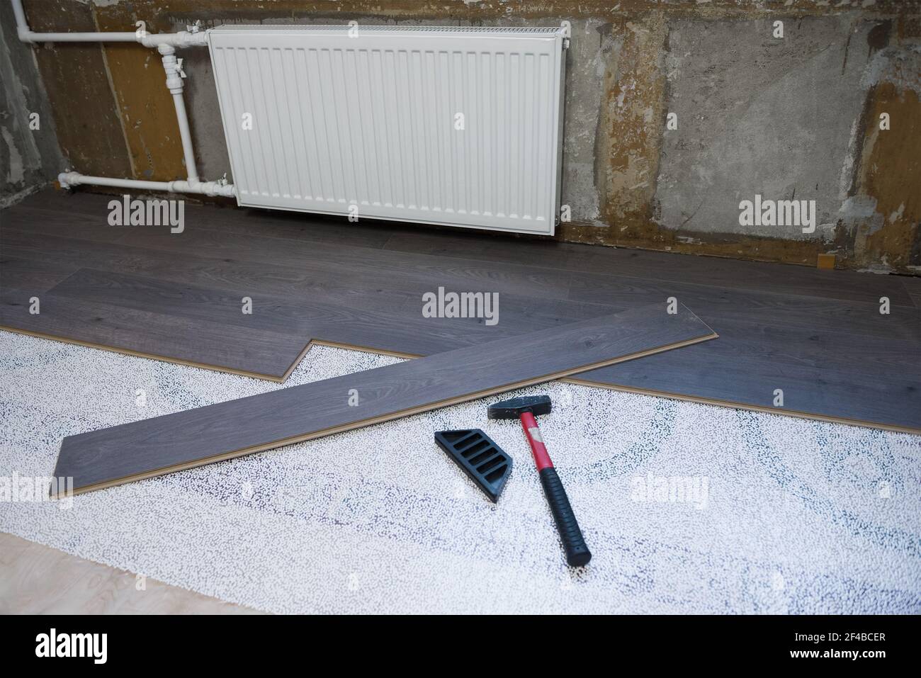 Laying laminate flooring in a small apartment room Stock Photo - Alamy