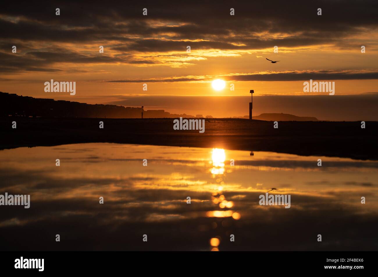 The sun rises over Boscombe beach in Dorset on the day of the Spring equinox. Picture date: Saturday March 20, 2021. Stock Photo