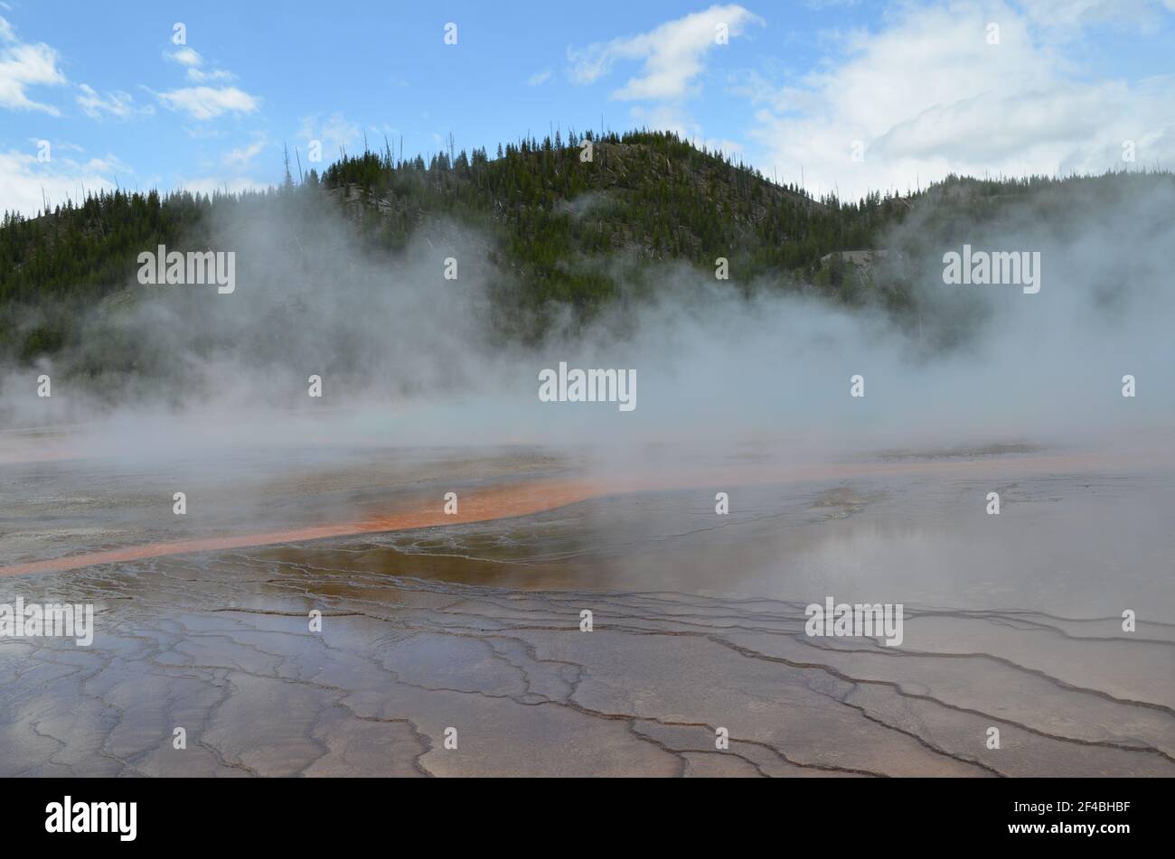 Late Spring in Yellowstone National Park: Streamer and Steam from Grand Prismatic Spring of the Excelsior Group in Midway Geyser Basin Stock Photo