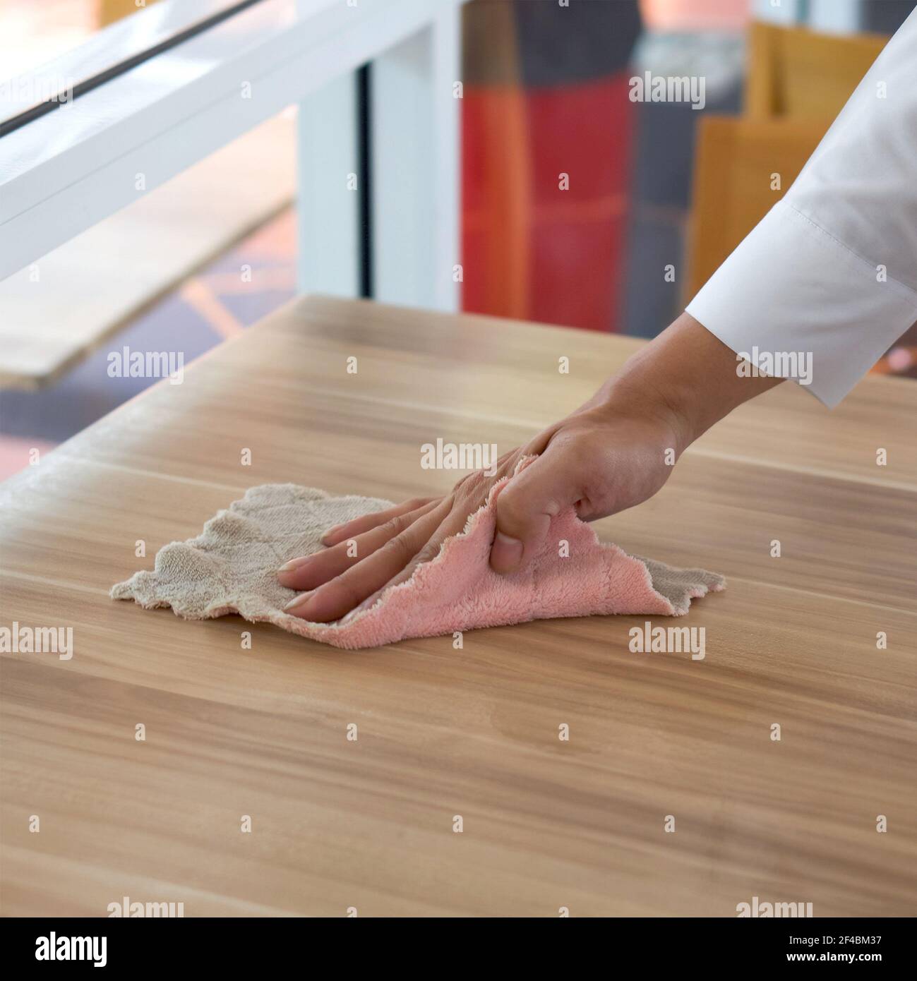 Closeup waiter's hand use a towel to wipe off the stains on the table