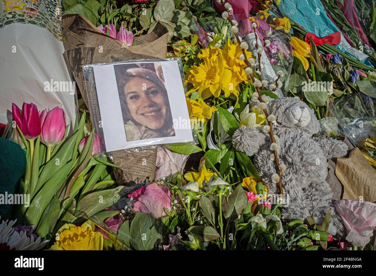 A picture of Sarah Everard sits amongst flowers left at the bandstand, Clapham Common where floral tributes have been building up over the few days Stock Photo