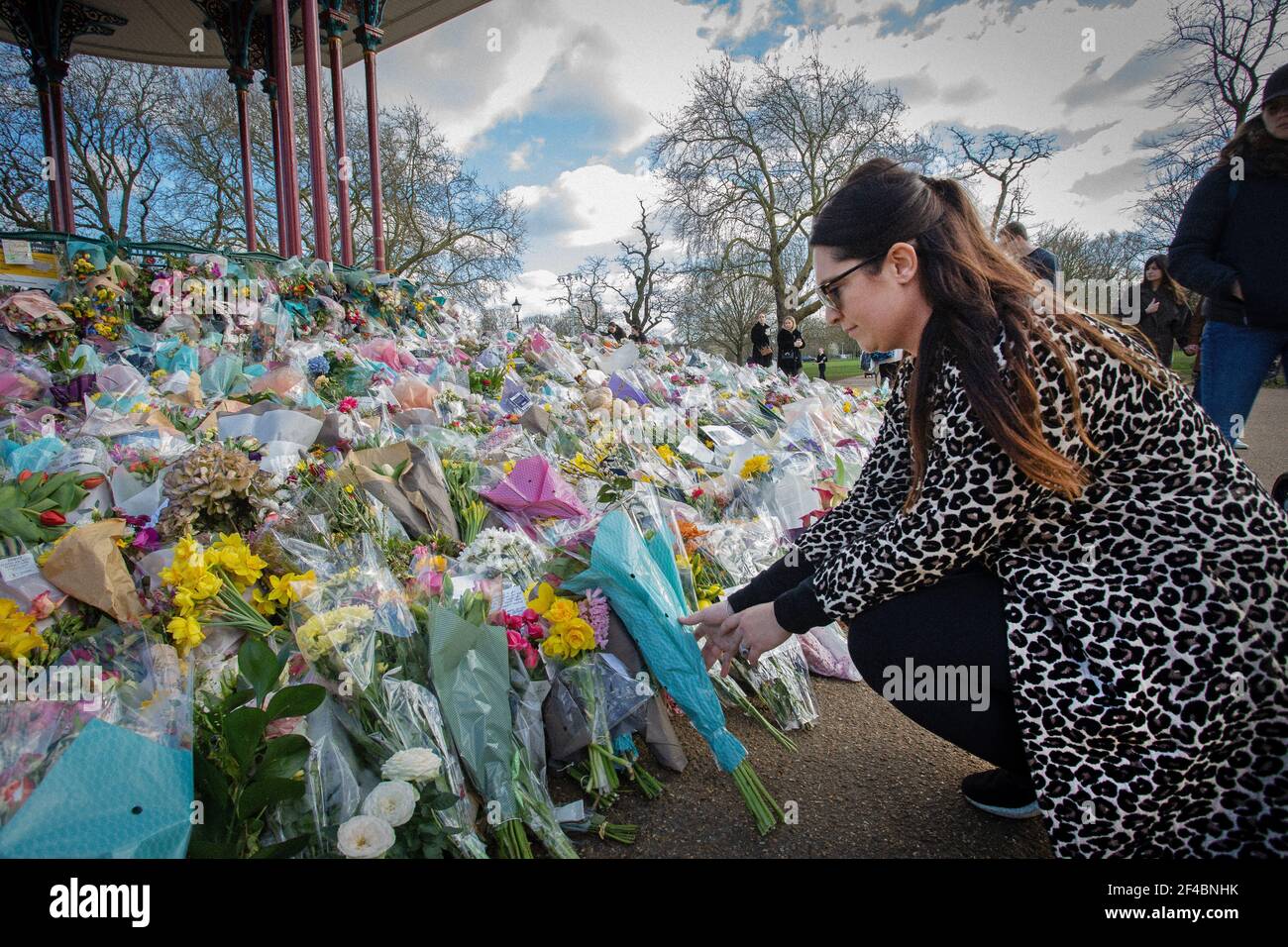 LONDON, ENGLAND - MARCH 19: Woman  lays flowers in tribute to Sarah Everard at the bandstand on Clapham Common on March 19, 2021 in London, Uk Stock Photo