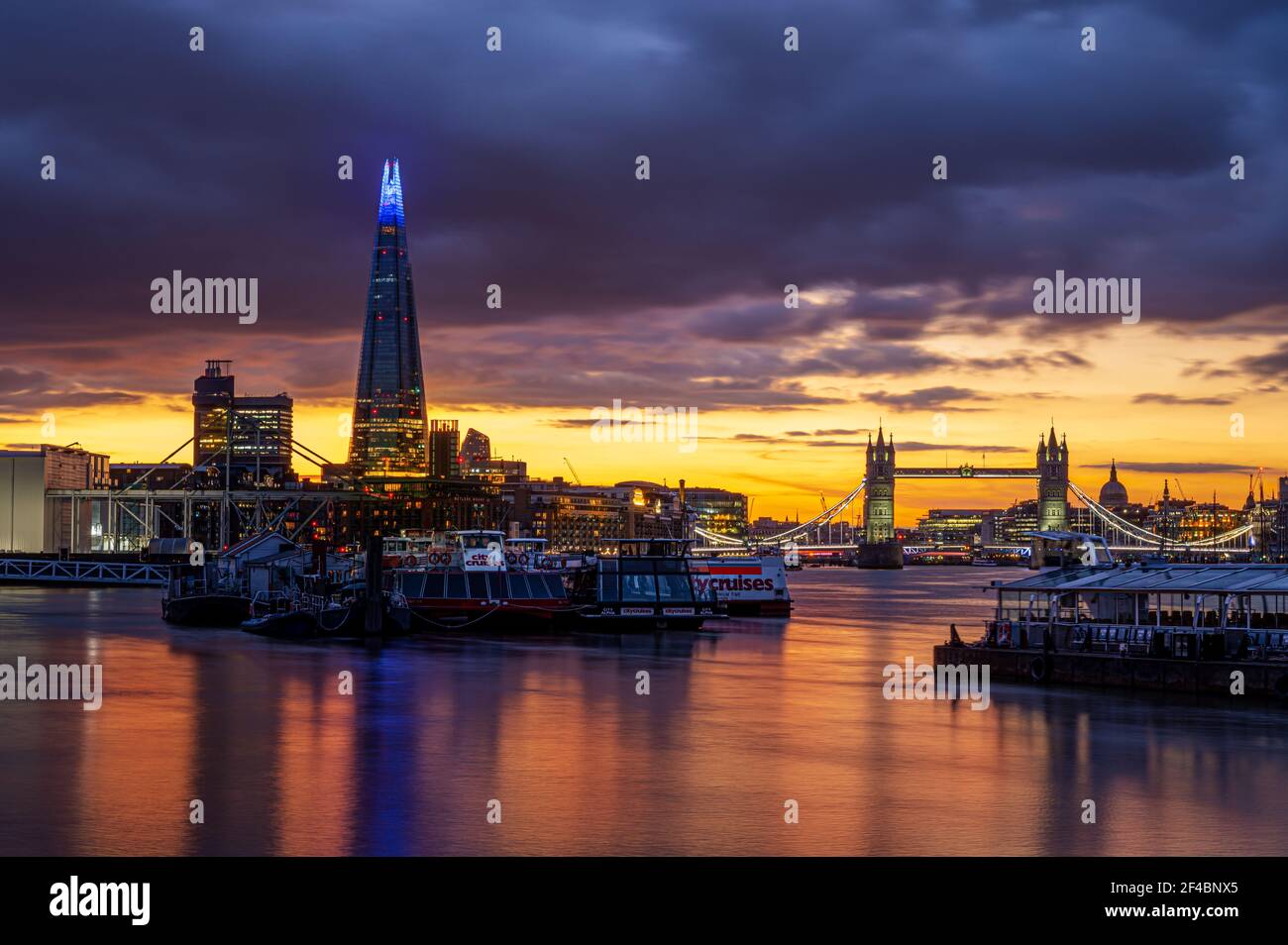 London, England, UK - March 19, 2021: Panoramic view of the city of London with a colorful sunset reflected into the Thames River Stock Photo