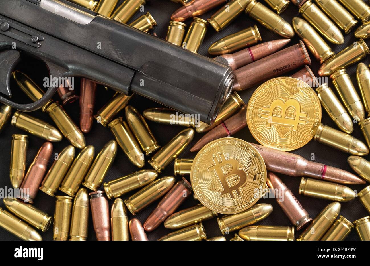 Bronze and brass gun bullets scattered on dark table, black pistol barrel,  golden bitcoin coins near - illegal use of cryptocurrency to purchase weapo  Stock Photo - Alamy