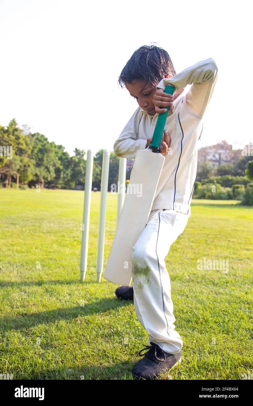 Young boy batting in protective gear during a cricket Stock Photo Alamy