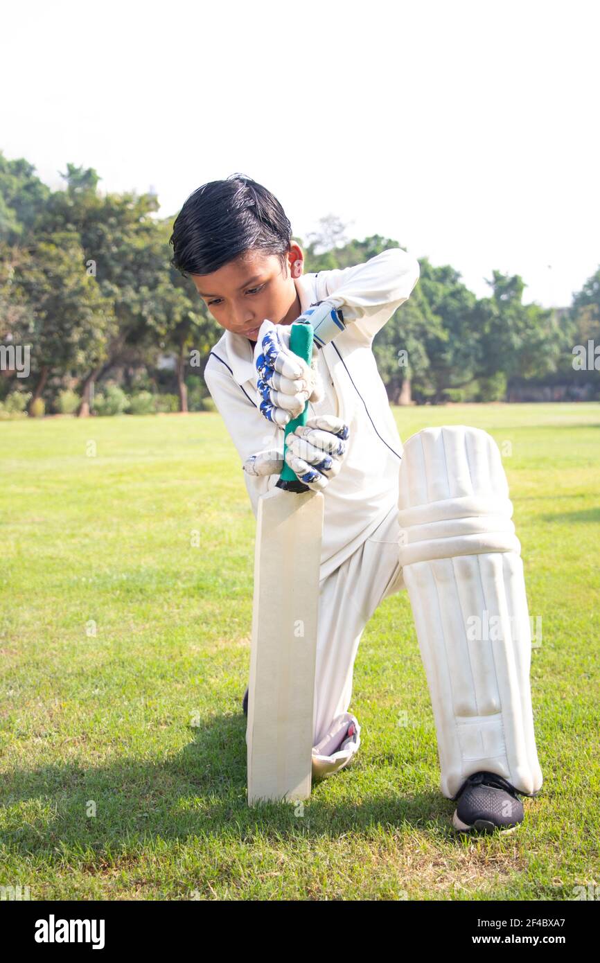 Confident boy wearing cricket uniform and playing Cricket Stock Photo