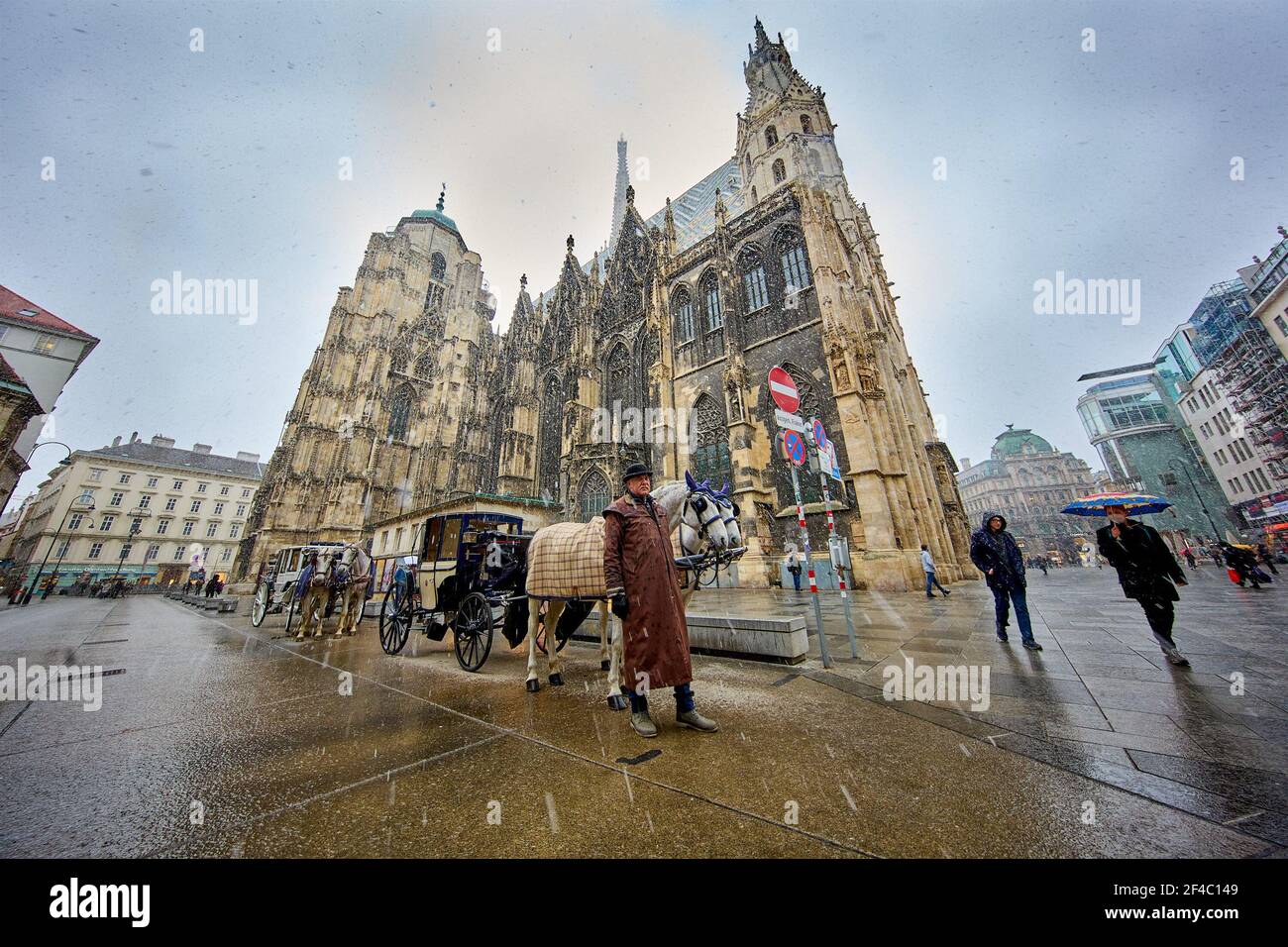 (210320) -- VIENNA, March 20, 2021 (Xinhua) -- Fiaker horse carriages are seen at the Stephansplatz square in Vienna, Austria, March 19, 2021. Viennese Fiaker coachmen have set up a feed box in the city center, where animal lovers can donate fruit and vegetables for the horses. As one of the most famous tourism projects of Vienna, Fiaker horse carriages encountered operational difficulties during the COVID-19 pandemic. (Photo by Georges Schneider/Xinhua) Stock Photo