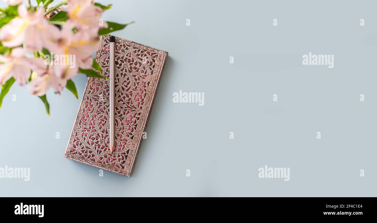 Flat lay of blue working table background with planner, pencil , and plants . Top view, mock up greeting card, craft Notebook and pen.Top view Stock Photo