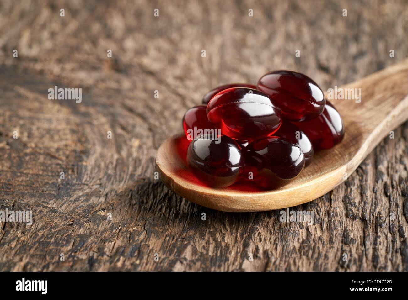Krill oil capsules on a wooden spoon on a table Stock Photo