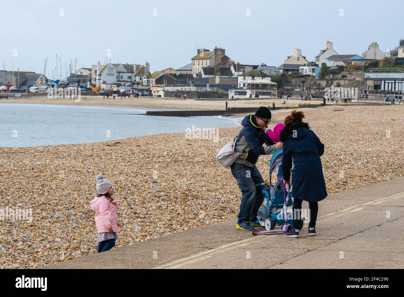 Lyme Regis, Dorset, UK. 20th Mar, 2021. UK Weather: After a dull start, sun breaks through the cloud at the seaside resort of Lyme Regis bringing a fine start to meteorological spring. People were out and about along the seafront enjoying the lovely mild weather. Credit: Celia McMahon/Alamy Live News Stock Photo