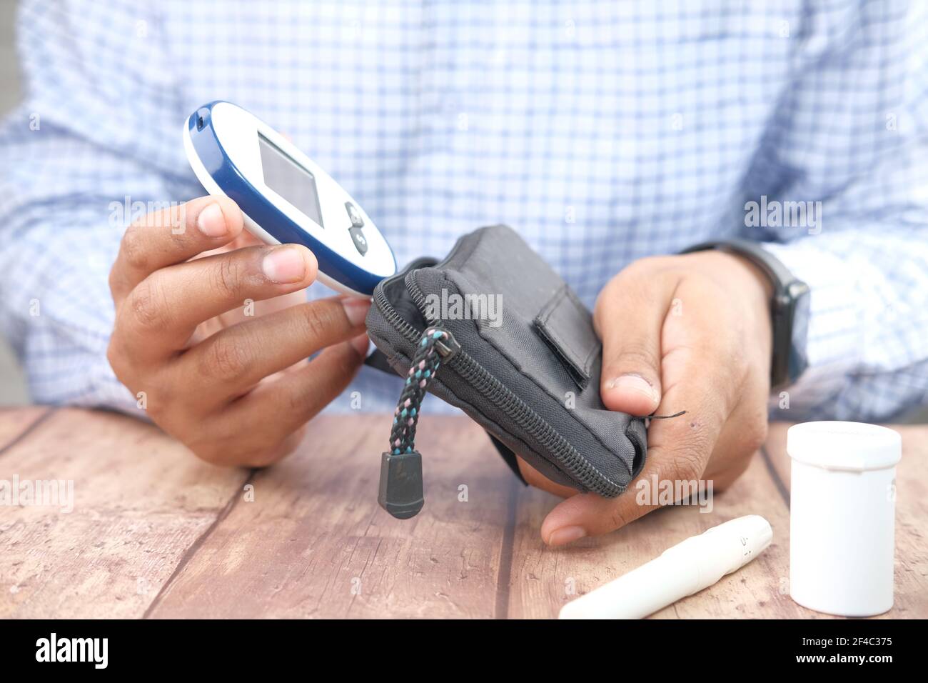 young man putting glucose meter in a small bag Stock Photo Alamy