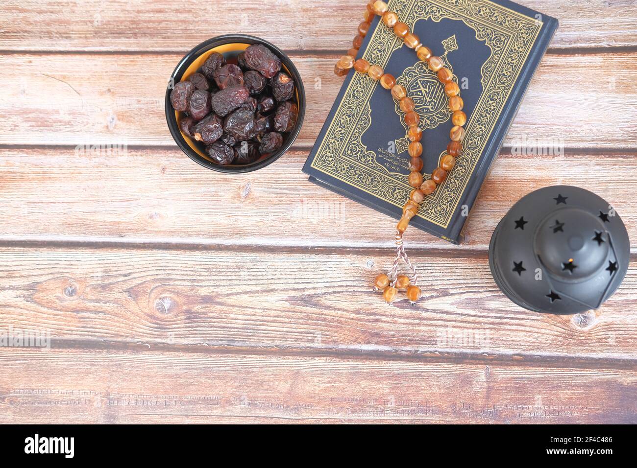 top view of date fruit , Holy book Quran and rosary on table, Stock Photo
