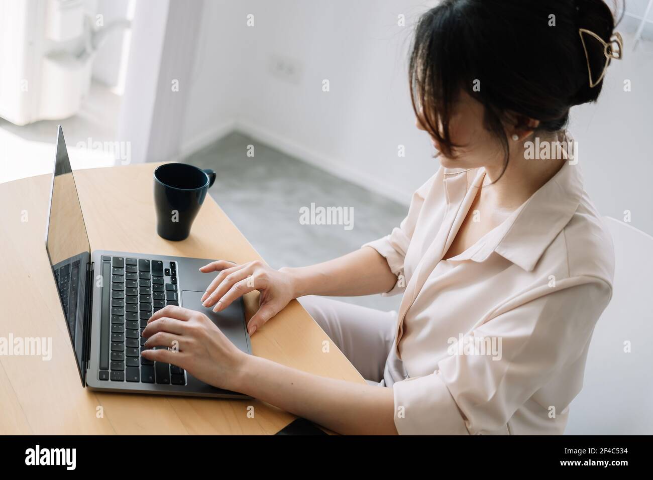 Young asian businesswoman sitting front open portable laptop computer