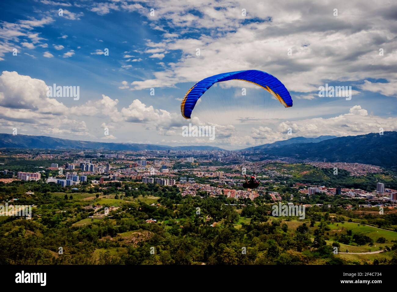 A paragllider flies over Bucaramanga, Colombia. Bucaramanga is a favorite destination for adventure sports enthusiasts.. Stock Photo