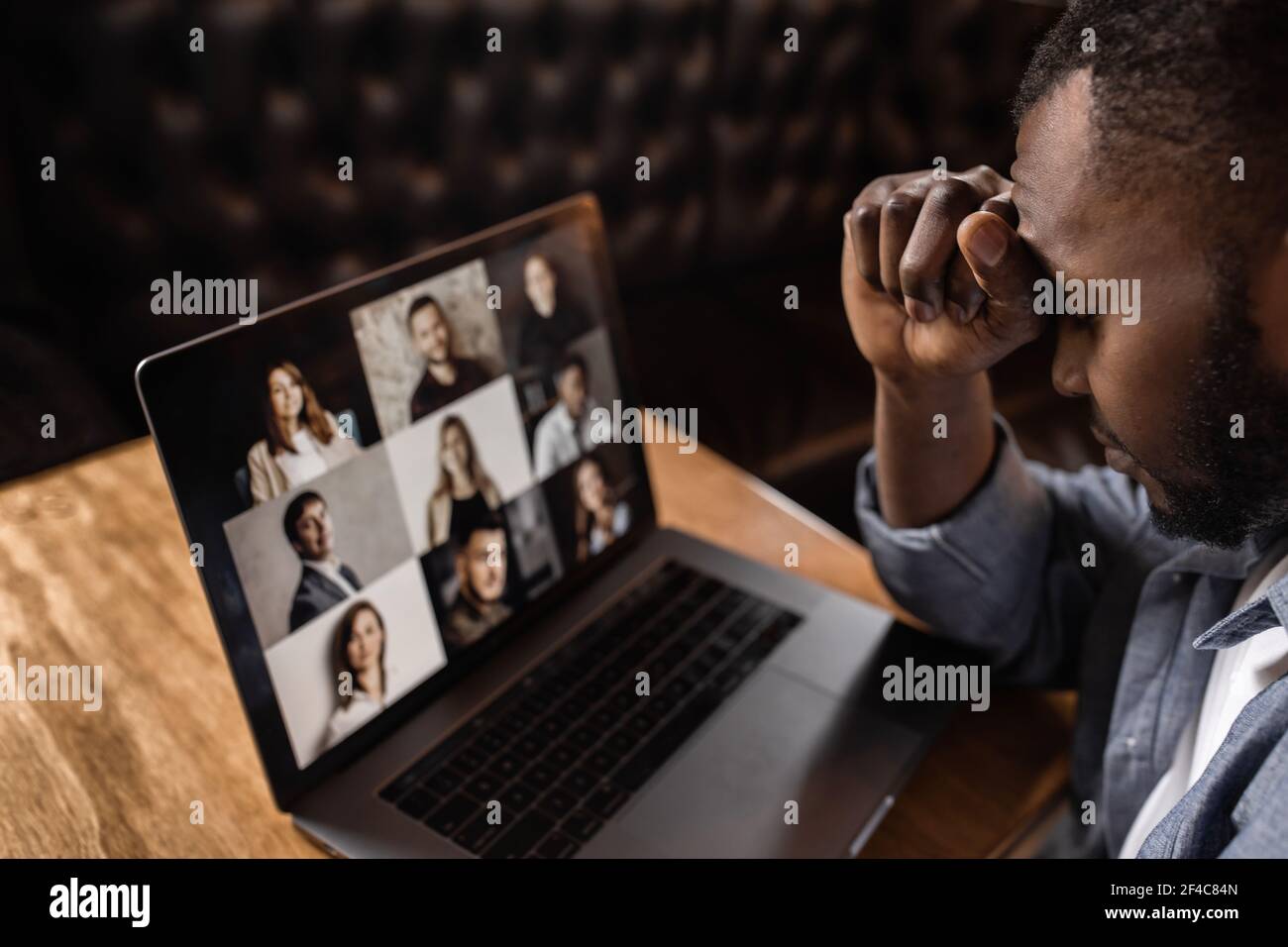 Exhausted tired African American businessman sitting at work desk with closed eyes, falling asleep, overworked young man, unmotivated student sleeping Stock Photo