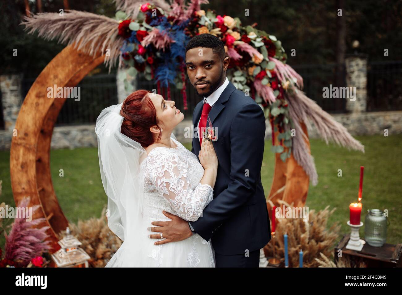 https://c8.alamy.com/comp/2F4CBM9/lovely-couple-on-wedding-ceremony-handsome-african-american-man-with-adorable-white-woman-stand-near-decorated-arch-cuddling-enjoy-happy-2F4CBM9.jpg