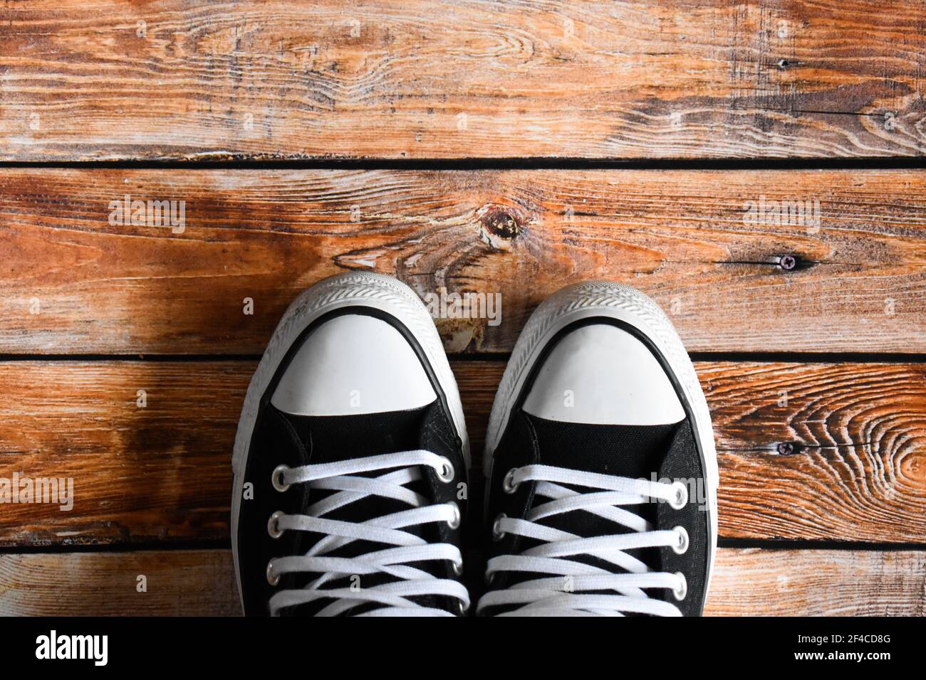 Black sneakers on a wooden floor Stock Photo - Alamy