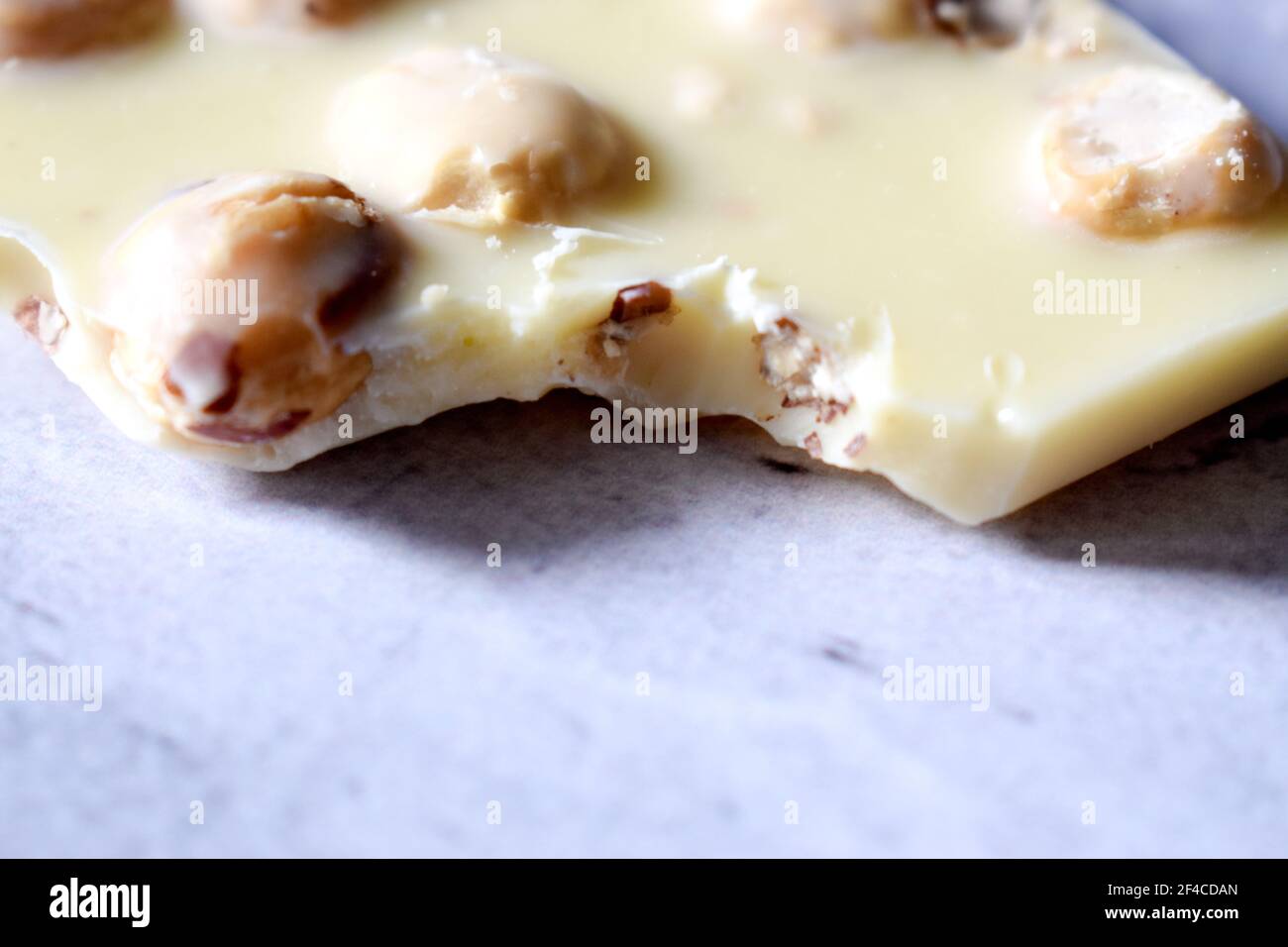 White chocolate with hazelnuts on a gray table close up Stock Photo