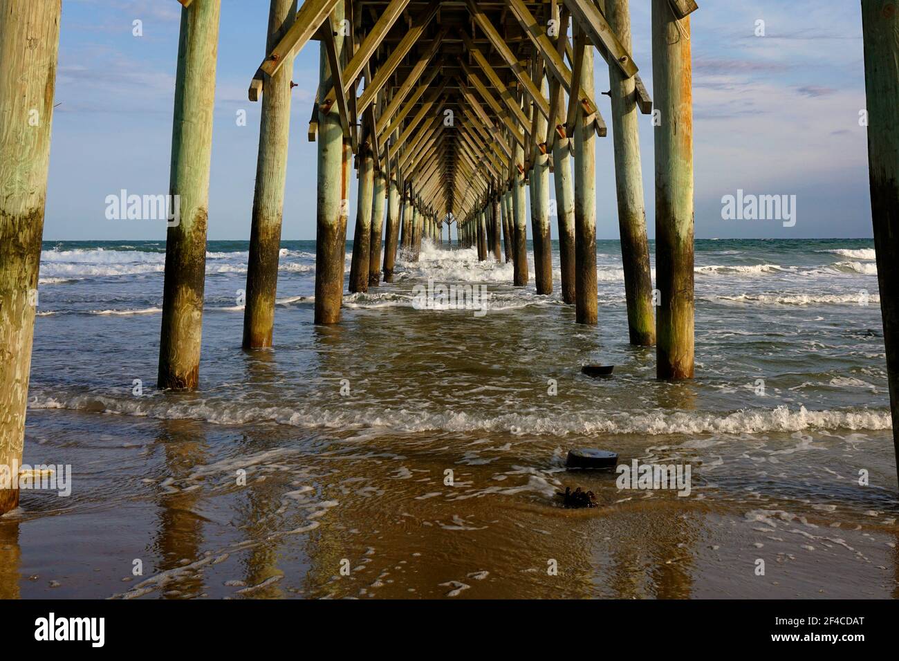 Waves crashing under the pier at the beach Stock Photo