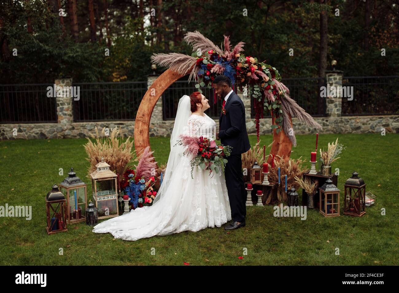 https://c8.alamy.com/comp/2F4CE3F/lovely-couple-on-wedding-ceremony-handsome-african-american-man-with-adorable-white-woman-stand-near-decorated-arch-cuddling-enjoy-happy-2F4CE3F.jpg