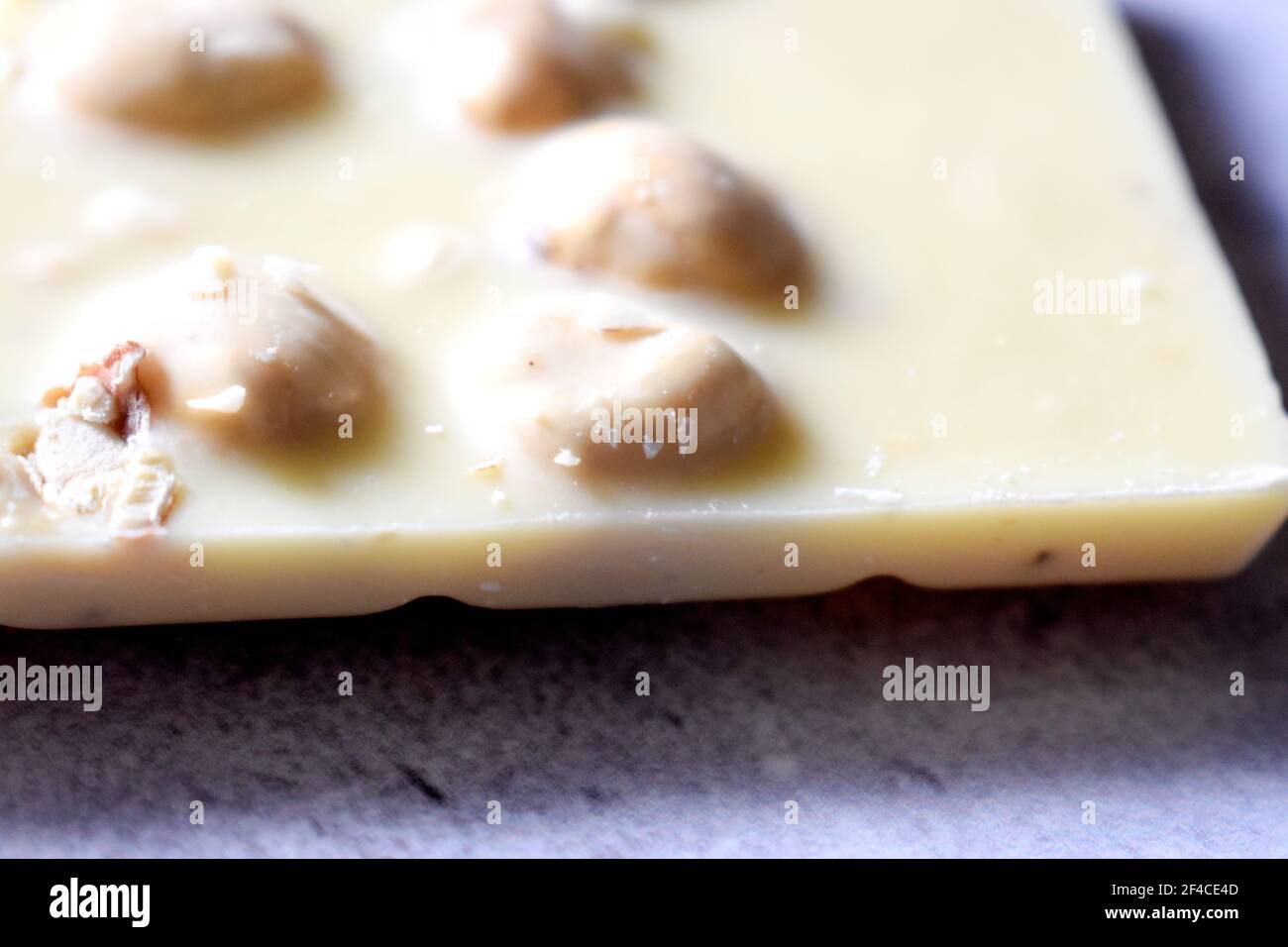 White chocolate with hazelnuts on a gray table close up Stock Photo