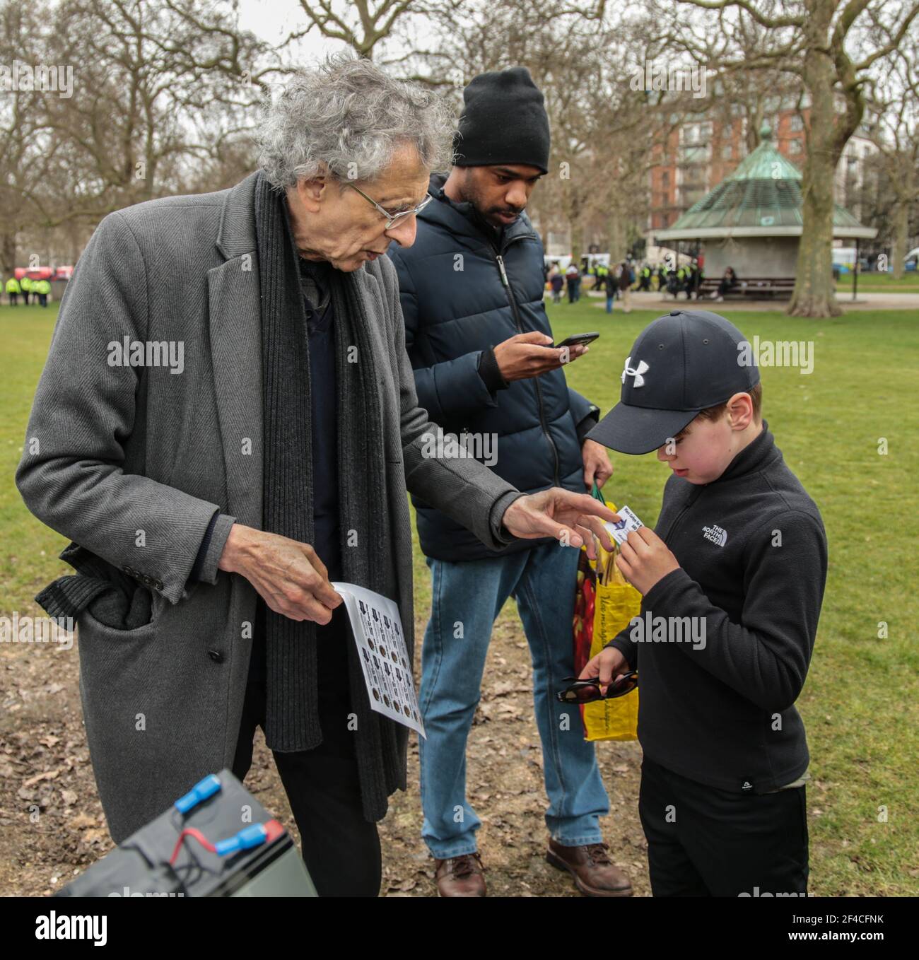 London UK 20 March 2021. Piers Corbyn English weather forecaster, businessman, activist, anti-vaxxer and conspiracy theorist arrives in Hyde Park to take part in todays anti lockdown ,anti vaccine and anti new laws to curb demonstrations ,currently been debated in parliament , giving a young fan a sticker with his name and face campaigning for London Mayor . Paul Quezada-Neiman/Alamy Live News Stock Photo