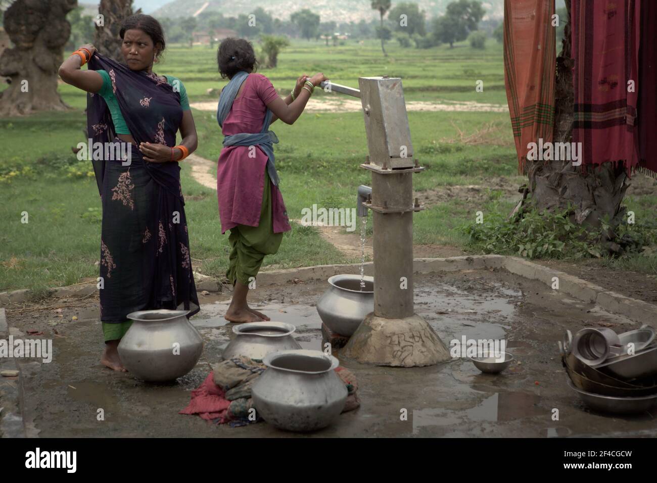 Women taking water from a communal water pump in Faldu village near Nalanda in Bihar, India. Over 3 billion people worldwide are at risk when using water because the health of their water source--rivers, lakes, or groundwaters--is unknown due to lack of water quality data, according to UN Water in their Summary Progress Update 2021 published on March 1, 2021 in Geneva. Stock Photo