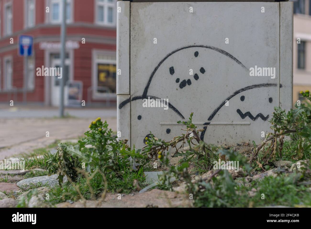 Electricity box with egg-shaped smiles at a street intersection Stock Photo