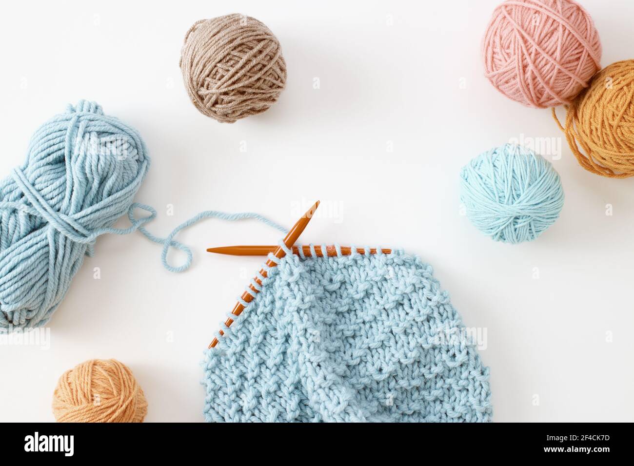 Knitting project in progress. A piece of knitting with ball of yarn and a knitting needles. Stock Photo