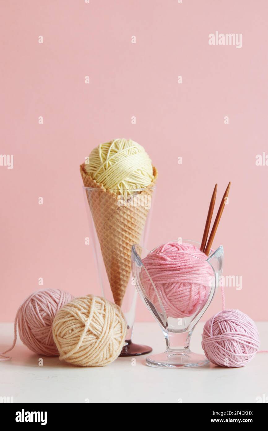 Pastel colored ball of yarn in a dessert bowl and in a waffle cone. Stock Photo