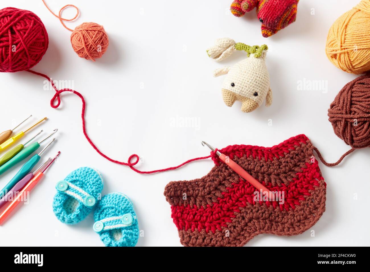 Colorful crochet project with hook and yarn, on white background. Stock Photo