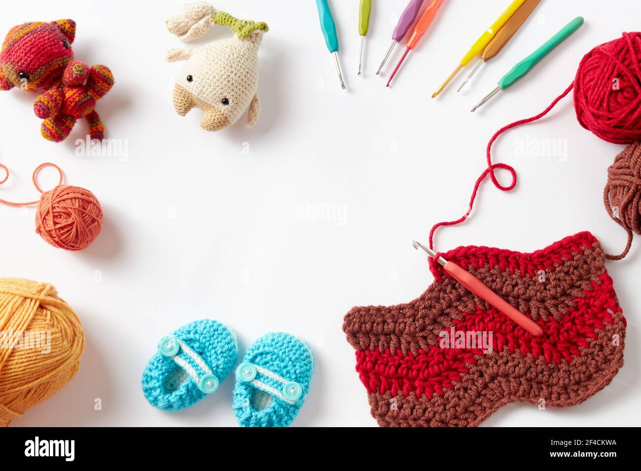 Colorful crochet project with hook and yarn, on white background. Stock Photo