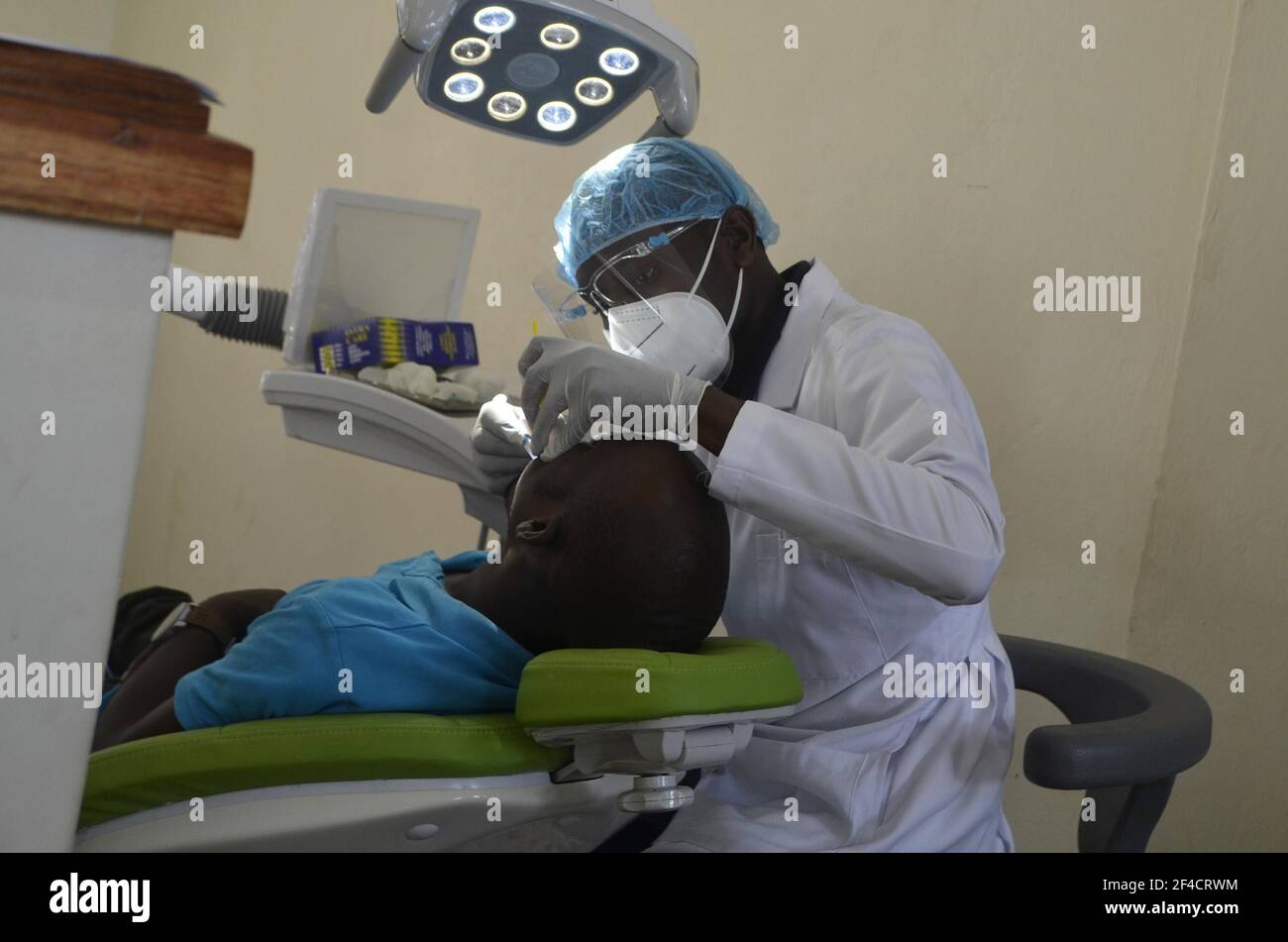 (210320) -- KAMPALA, March 20, 2021 (Xinhua) -- A health worker treats a patient during a free dental clinic event held to mark the World Oral Health Day at Makerere University in Kampala, Uganda, March 20, 2021. World Oral Health Day is celebrated every year on March 20 to promote worldwide awareness of oral diseases and the importance of oral hygiene. (Photo by Nicholas Kajoba/Xinhua) Stock Photo