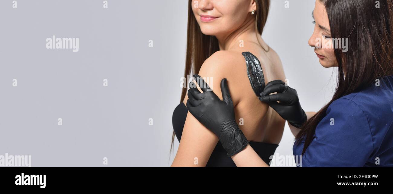 Beautician doing waxing depilation on back, body care and femininity concept Stock Photo